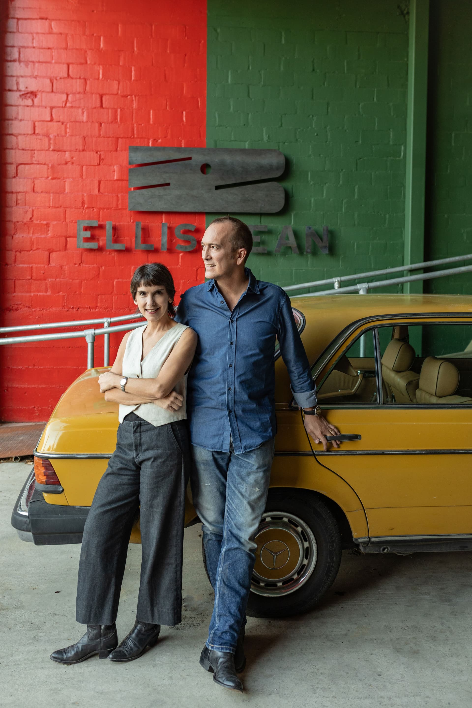 A man and a woman stand in front of a car