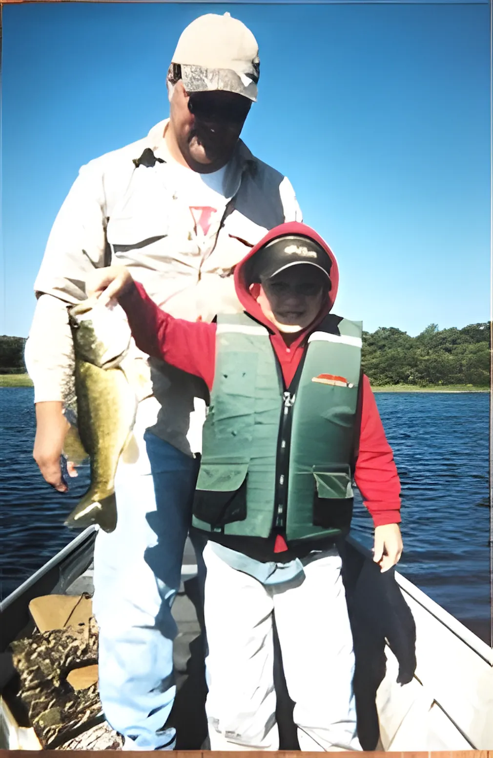 Father and child fishing together from a boat, representing family traditions and time spent outdoors