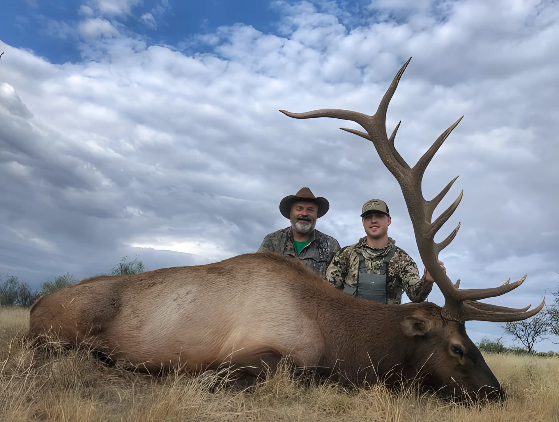 Father and son with a harvested bull elk, reflecting hunting, family legacy, and a lifelong connection to the outdoors