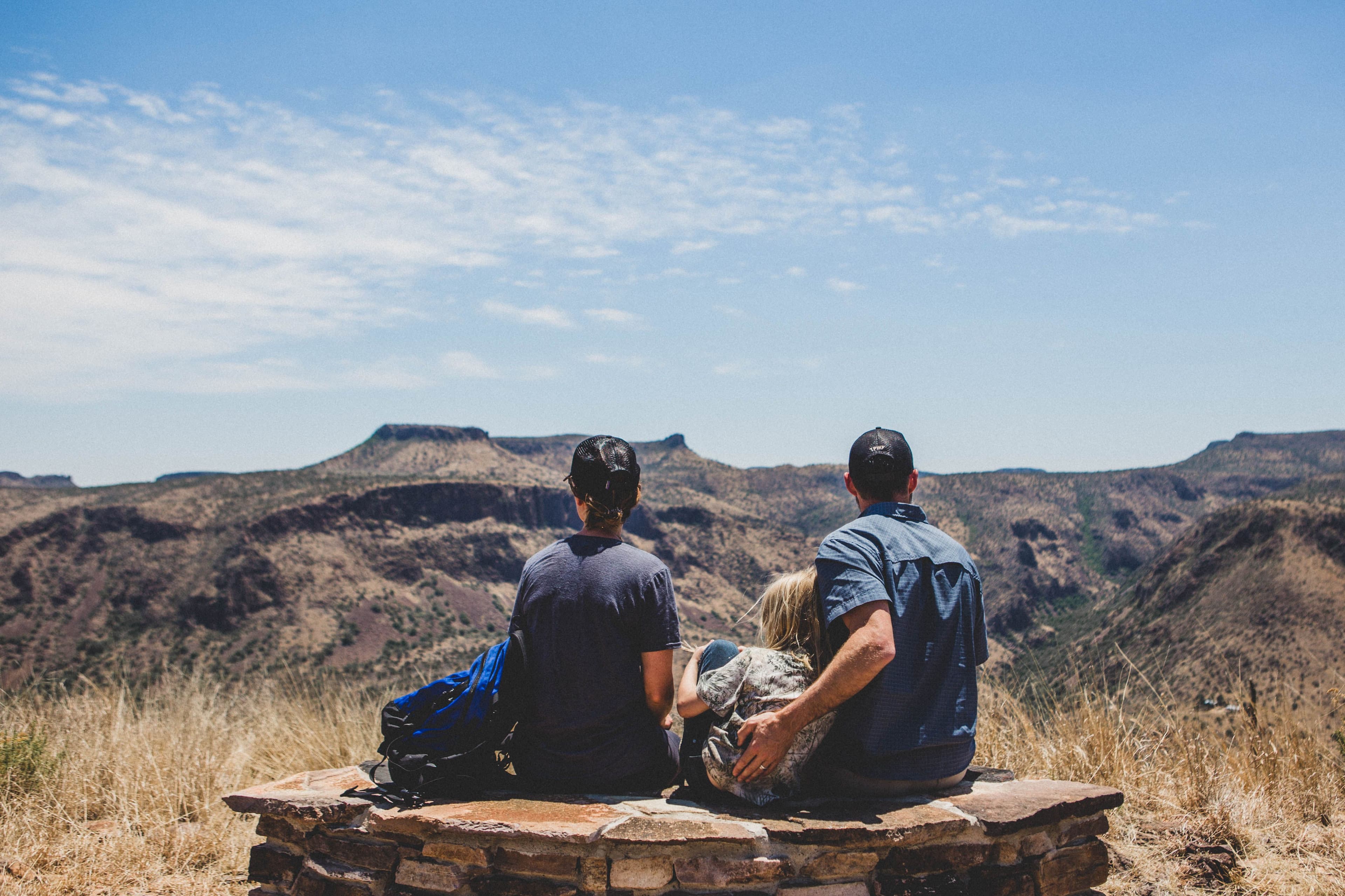 A family sits and enjoys a vista